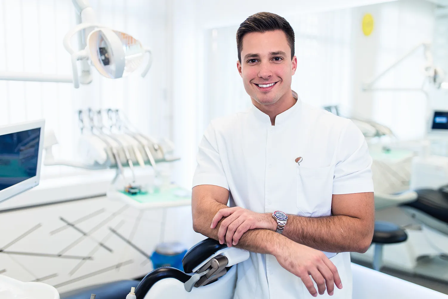 Männlicher Zahnarzt im weißen Laborkittel des Arztes